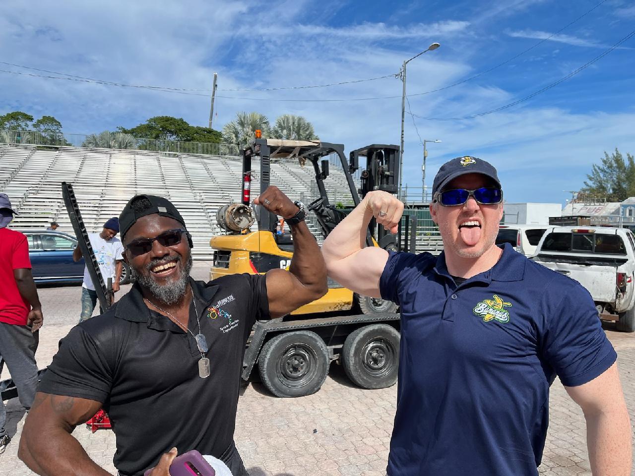 Tim Naddy flexing alongside a colleague at a community event