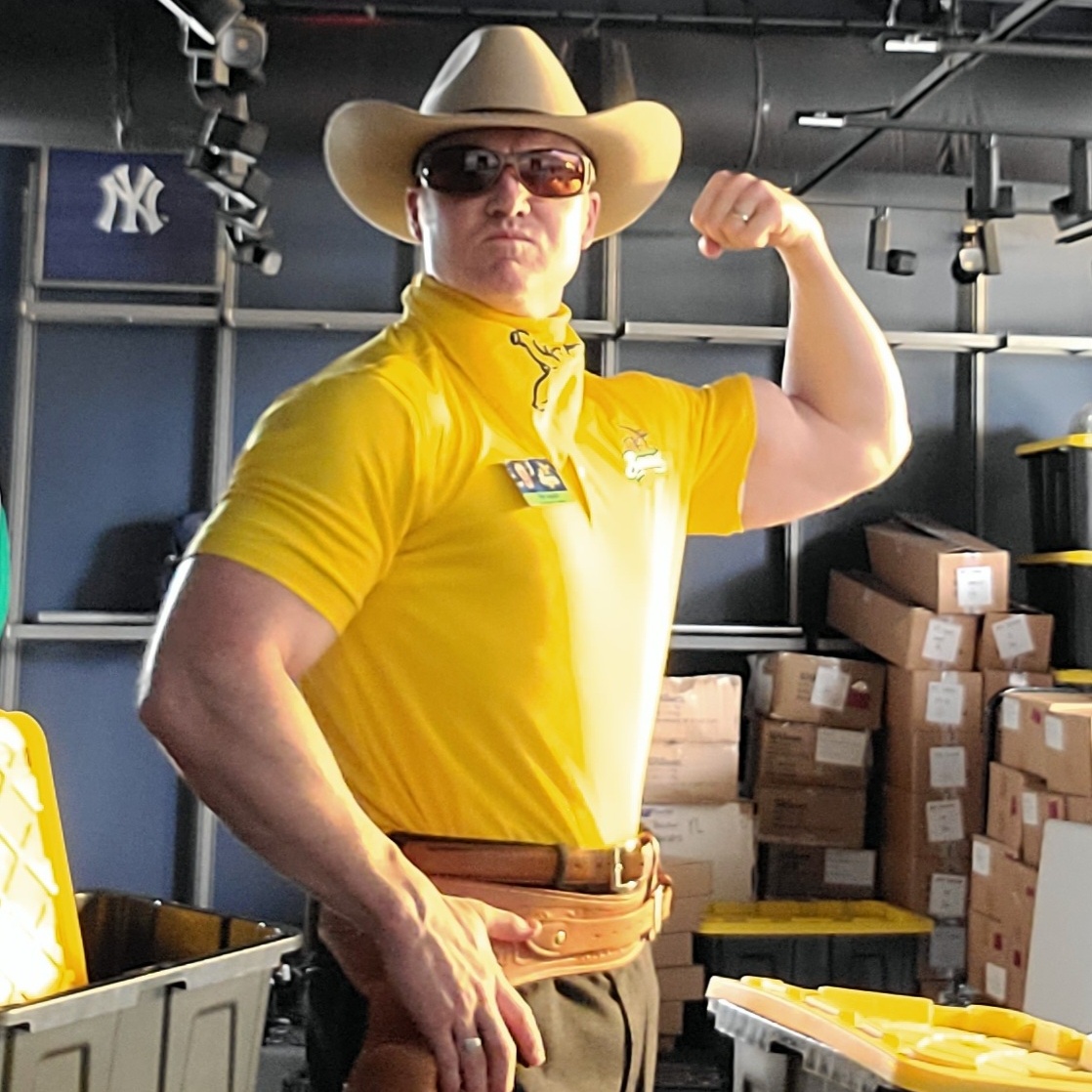Tim Naddy flexing in a Savannah Bananas polo and cowboy hat in the clubhouse